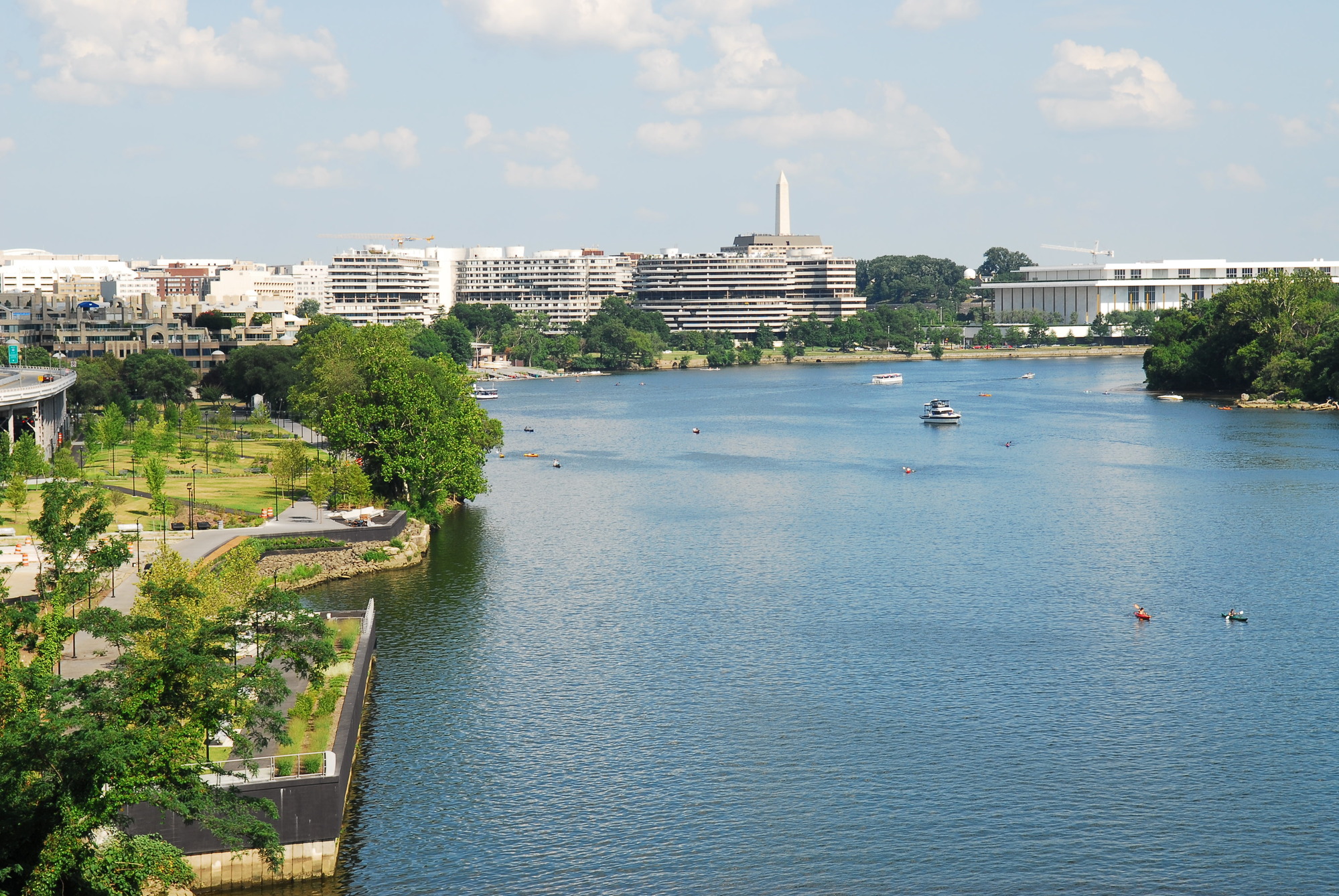The blue Potomac River flows next to the green, grassy Georgetown Waterfront Park