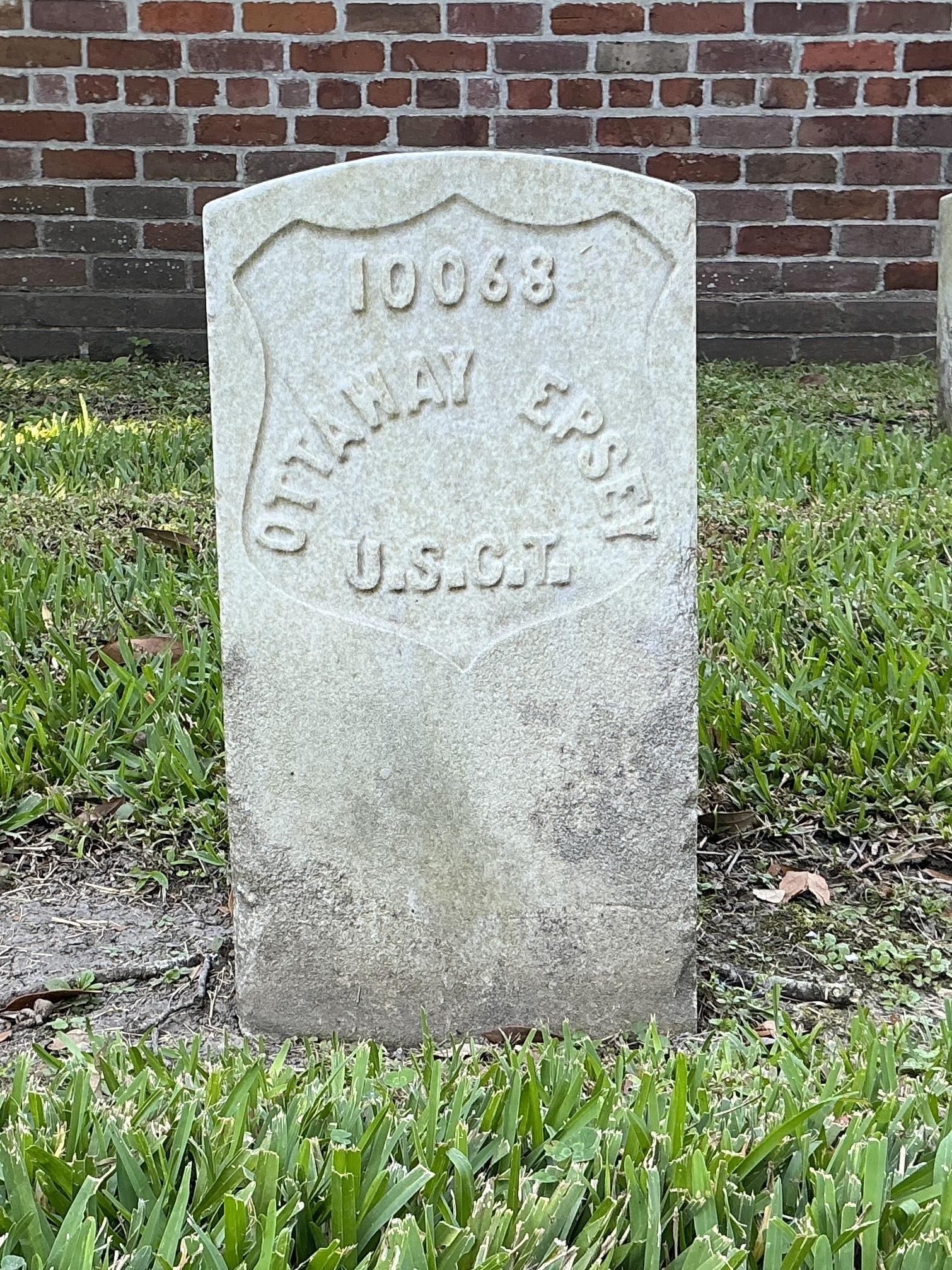 Front of historic upright marble headstone with recessed shield face.