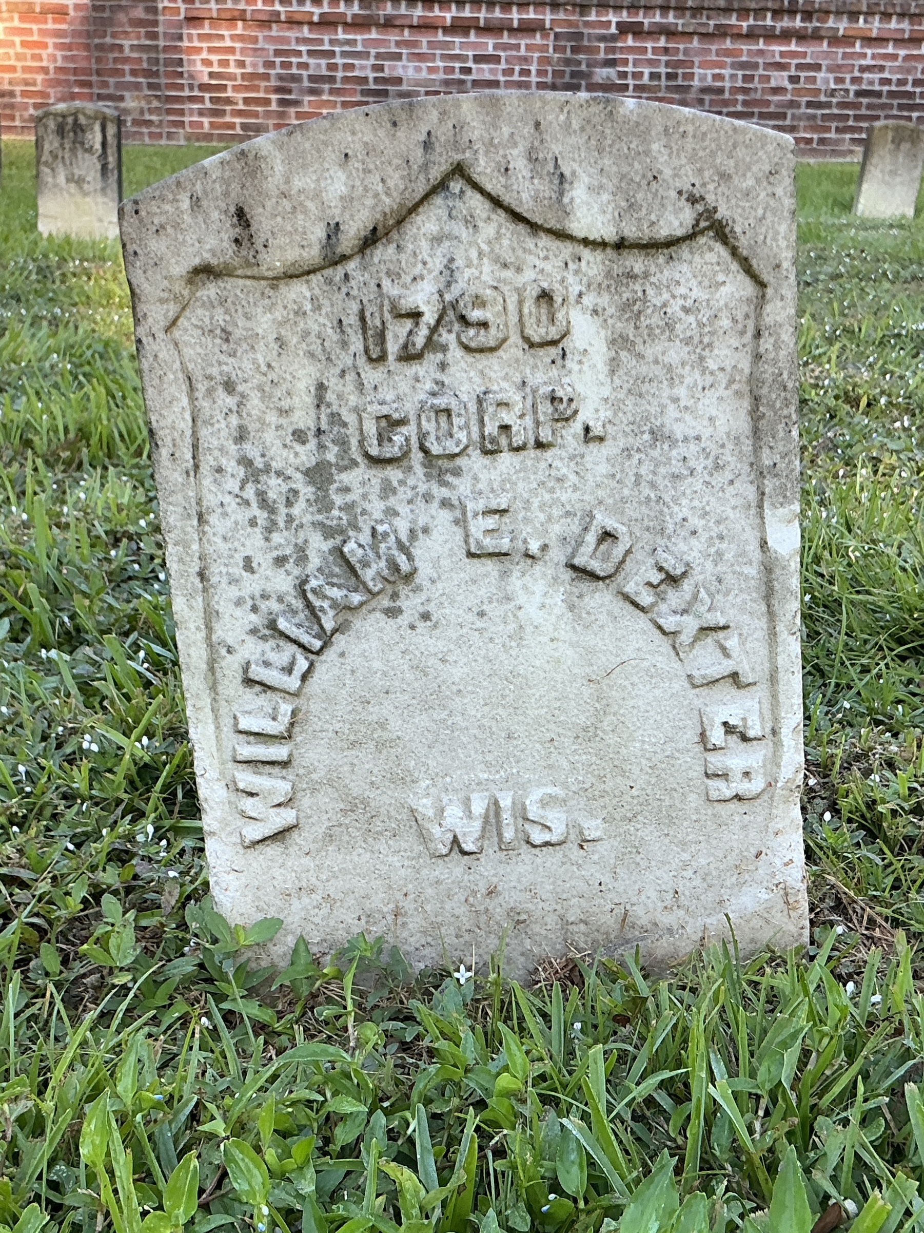 Front of historic upright marble headstone with recessed shield face.