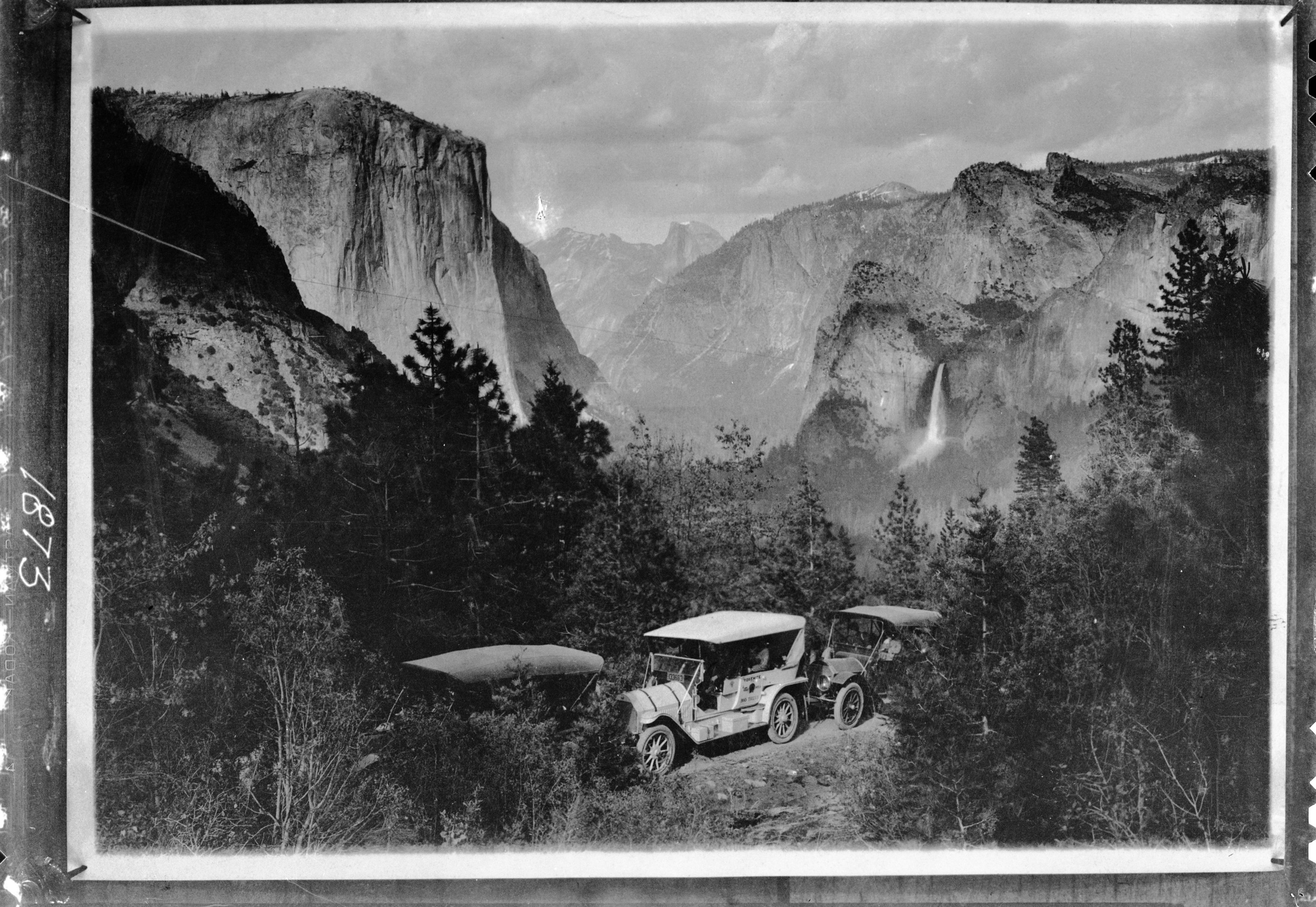 First regular autostage into Yosemite Valley. Mr. Edwin T. Huffman on June 2, 1915, drove the first auto stage of Yosemite Stage and Turnpike Co. into Yosemite Valley over the Wawona Road. This picture taken at that time by Julius Theodore Boysen marked passing of horsedrawn stage.