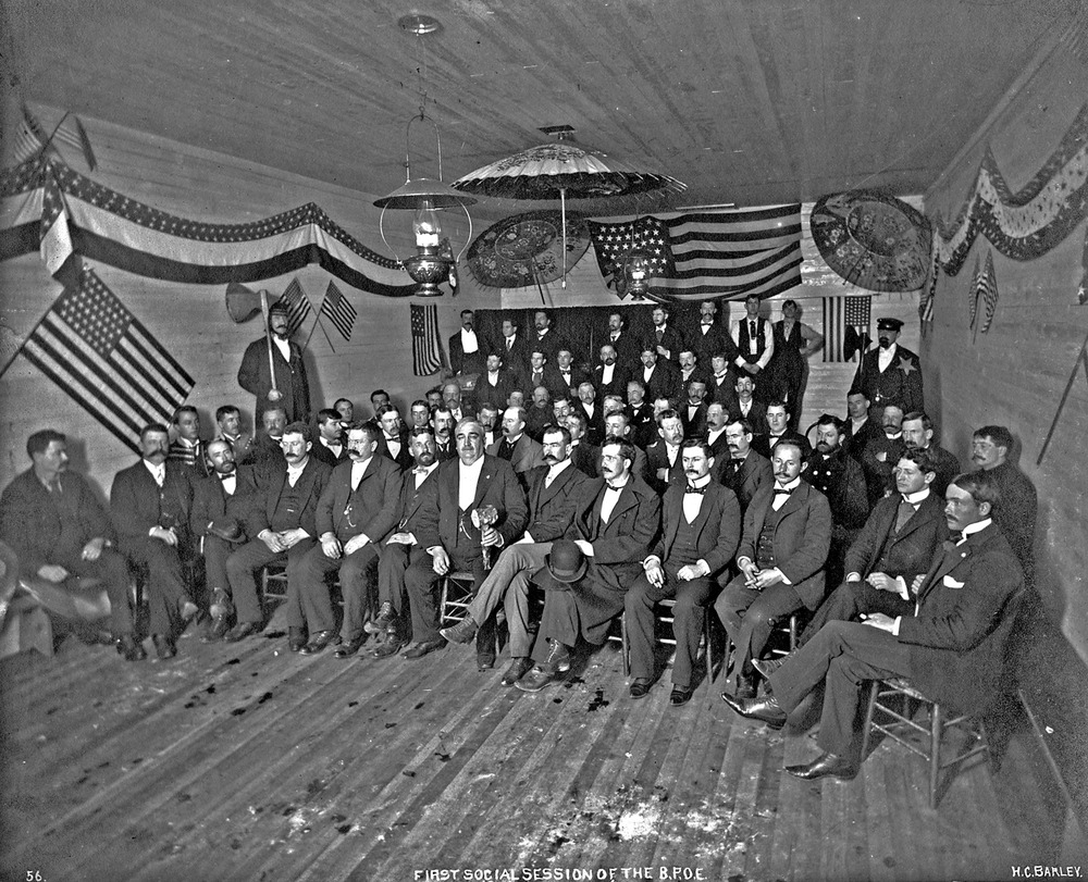 Black and White historic image of a group of uniformed men in a decorated building 