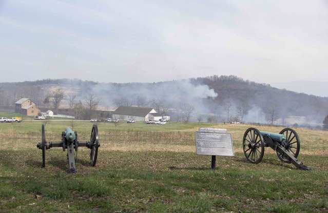 From the vantage point of Bachman’s Battery along South Confederate Avenue, the prescribed fire can be seen moving south (to the right of the Bushman house and barn) and to the east (the concentrated smoke halfway up the slope of Big Round Top).