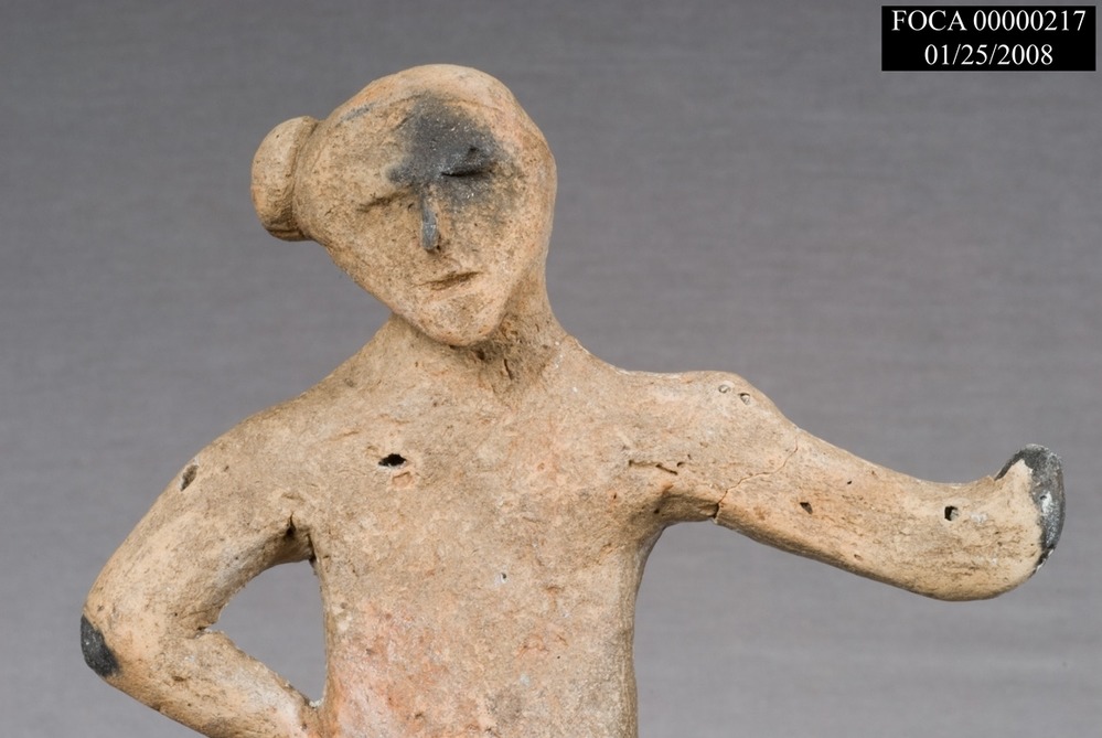 a stone figure of a person with a bun harstyle