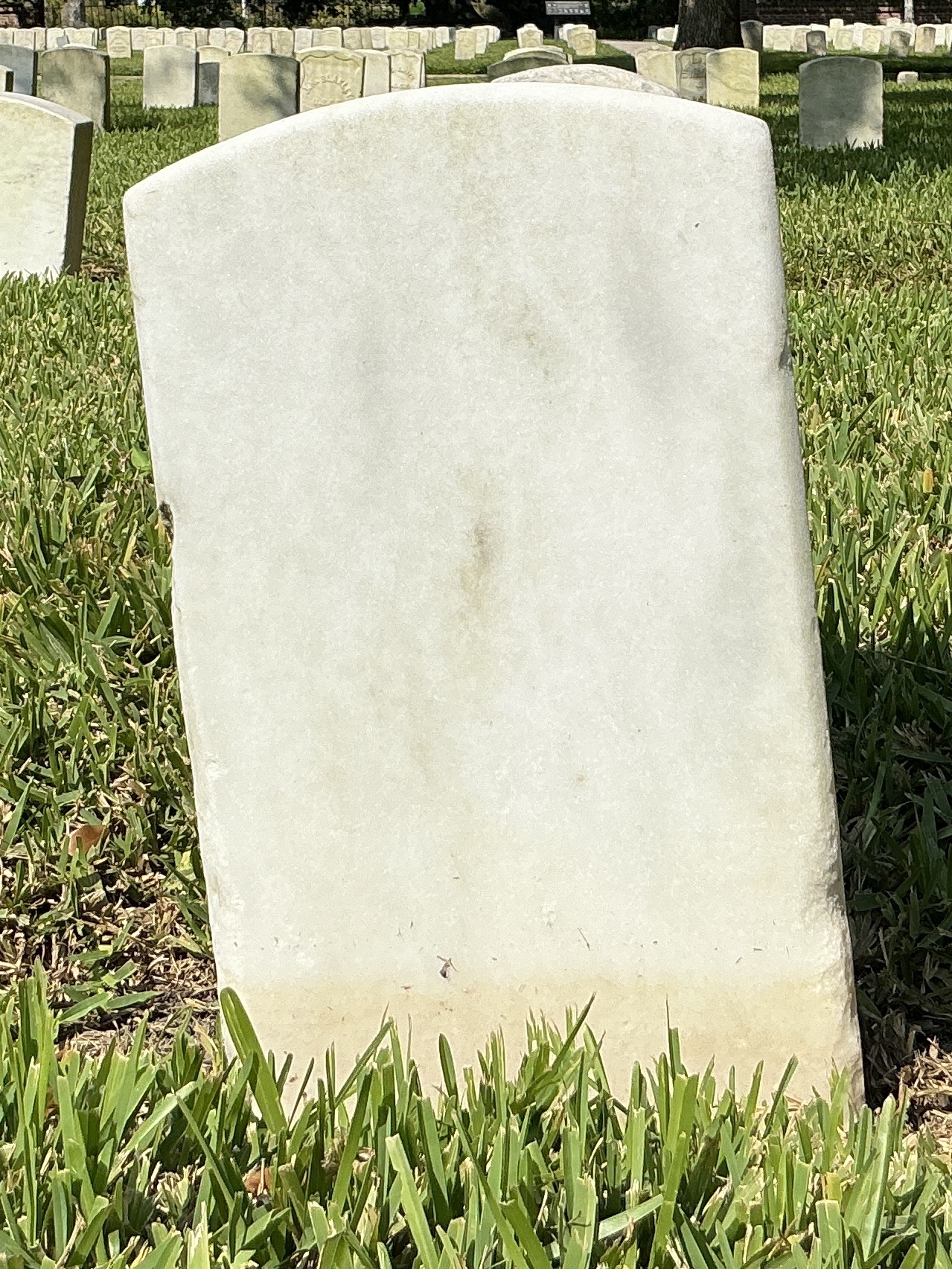 Back of historic upright marble headstone with recessed shield with recessed lettering face.