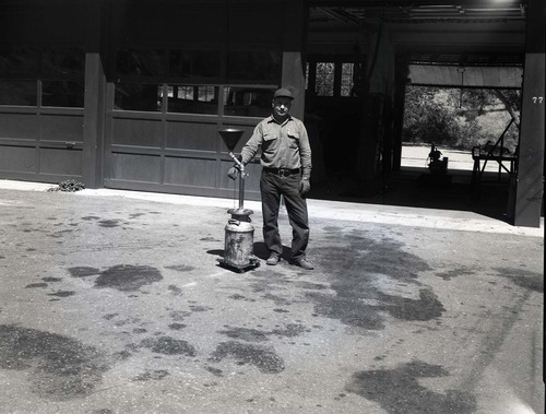 BW Photos of man standing next to maintenance equipment.