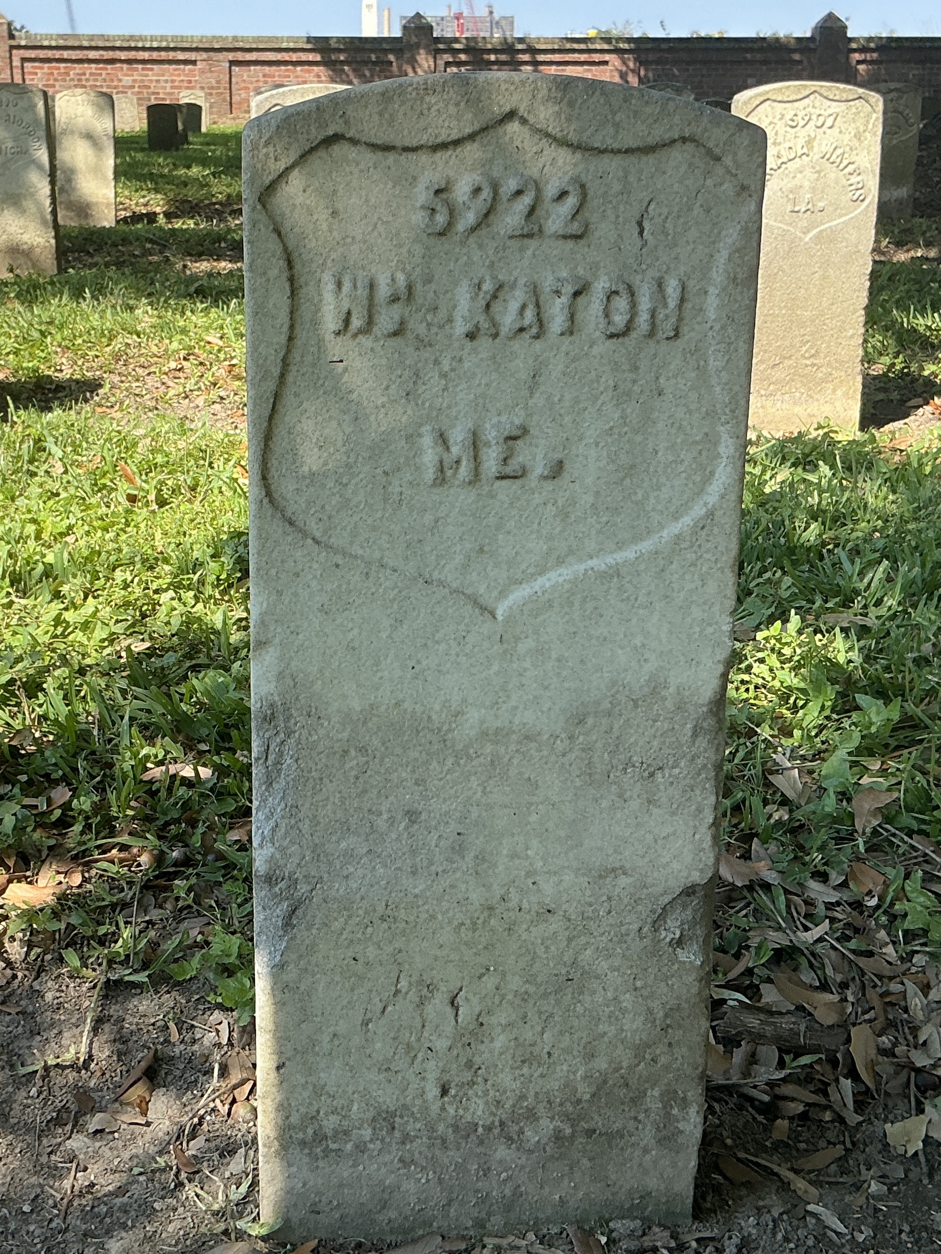 Front of historic upright marble headstone with recessed shield face.