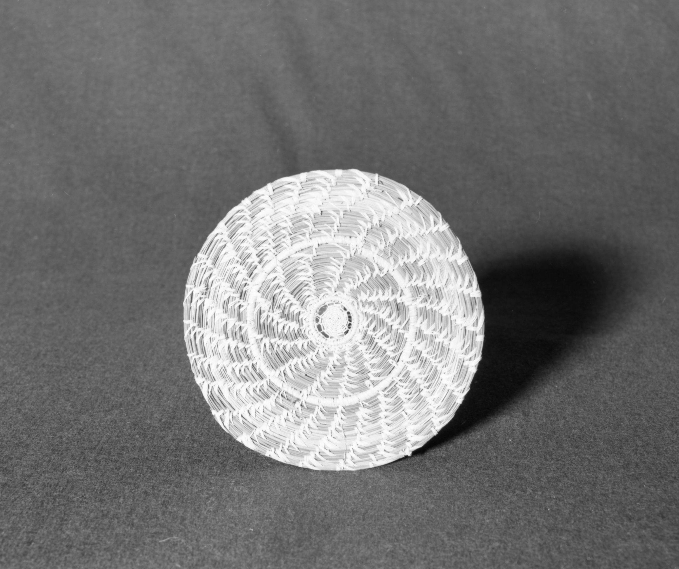 Marie Rozier Collection, Catalog No. 233. Object: Wall plaque. Dimensions: 6 3/4". Materials: pine needles, raffia. Collection History: Made by Thyllie Wolf. Purchased for $3.50. Photographed by Michael Dixon, December 1982. Catalogued by Craig Bates and Barbara Beroza. Yosemite Collections, National Park Service.