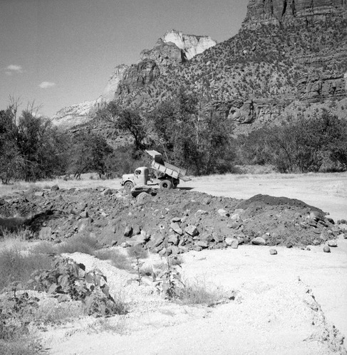 Amount of debris collected first day after flood. Material stockpiled for road construction. [One of two images on single strip of film. See also ZION 8581 frame 2.]