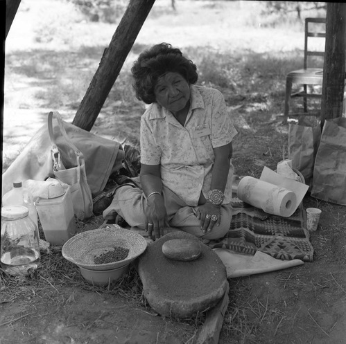 Mary Snow, Paiute, demonstrates the grinding with a metate and mano at the first annual Folklife Festival at Zion National Park Nature Center, September 1977.