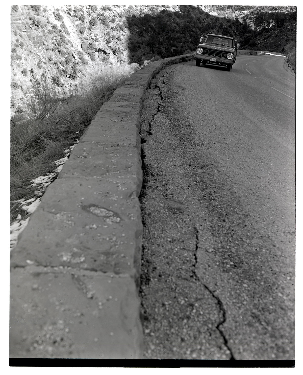 Truck driving along road in need of repair along the Zion-Mt. Carmel Highway switchbacks.