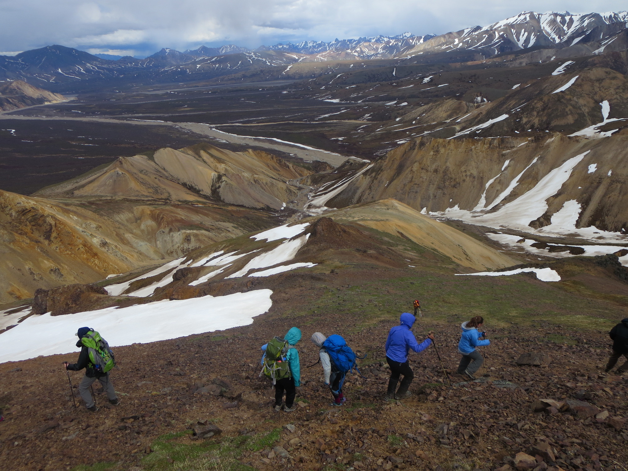 six teenagers hiking down a rocky mountain