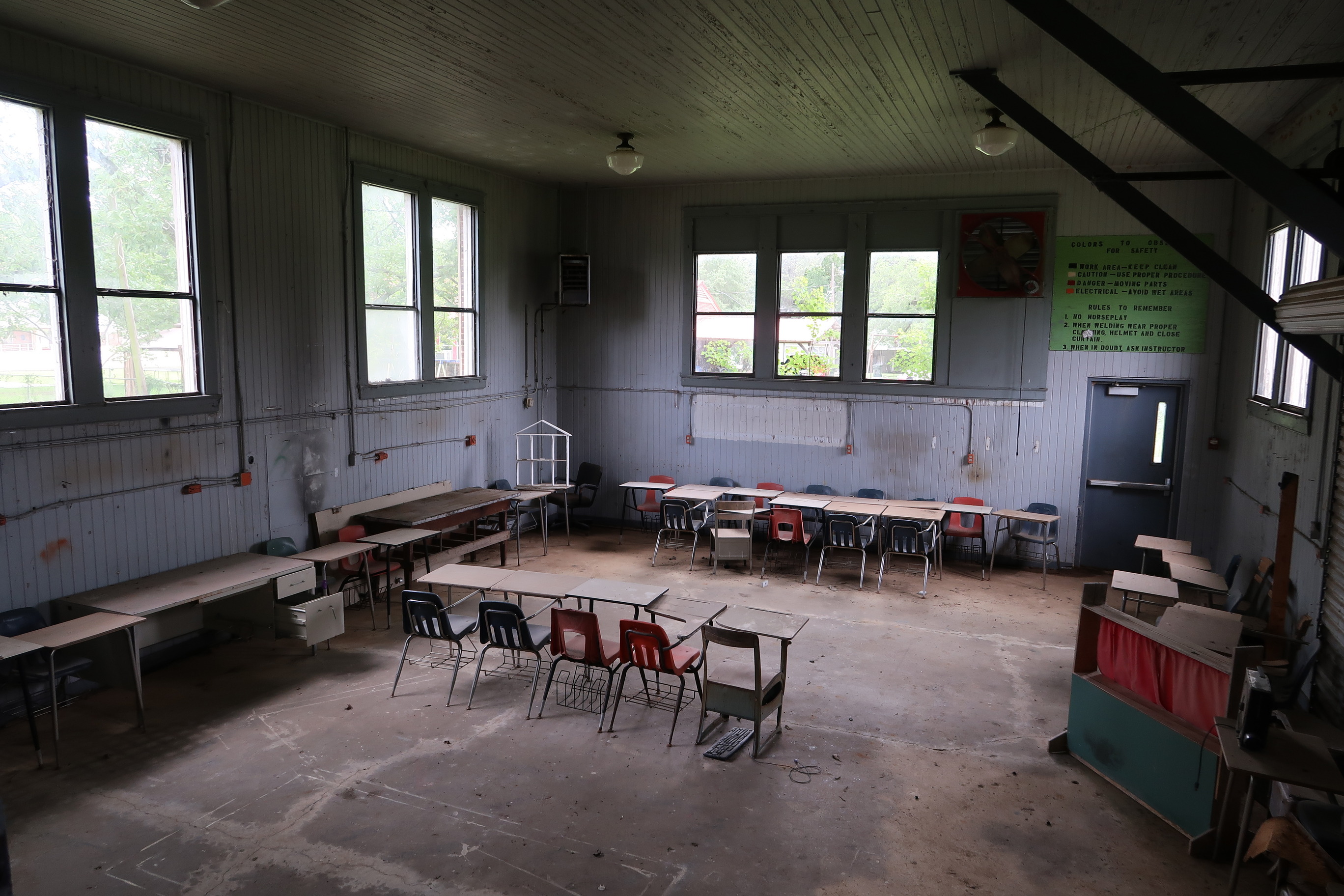 Interior of the vocational education area of the Marion Rosenwald School with large open area, desks and chairs, and windows. 