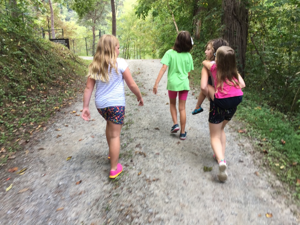 girls walking down a dirt road