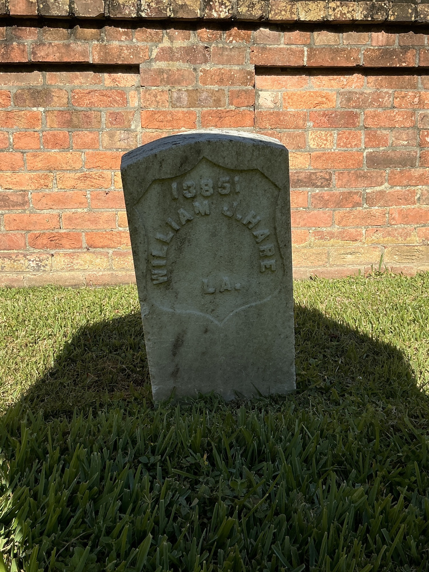 Front of historic upright marble headstone with recessed shield face.