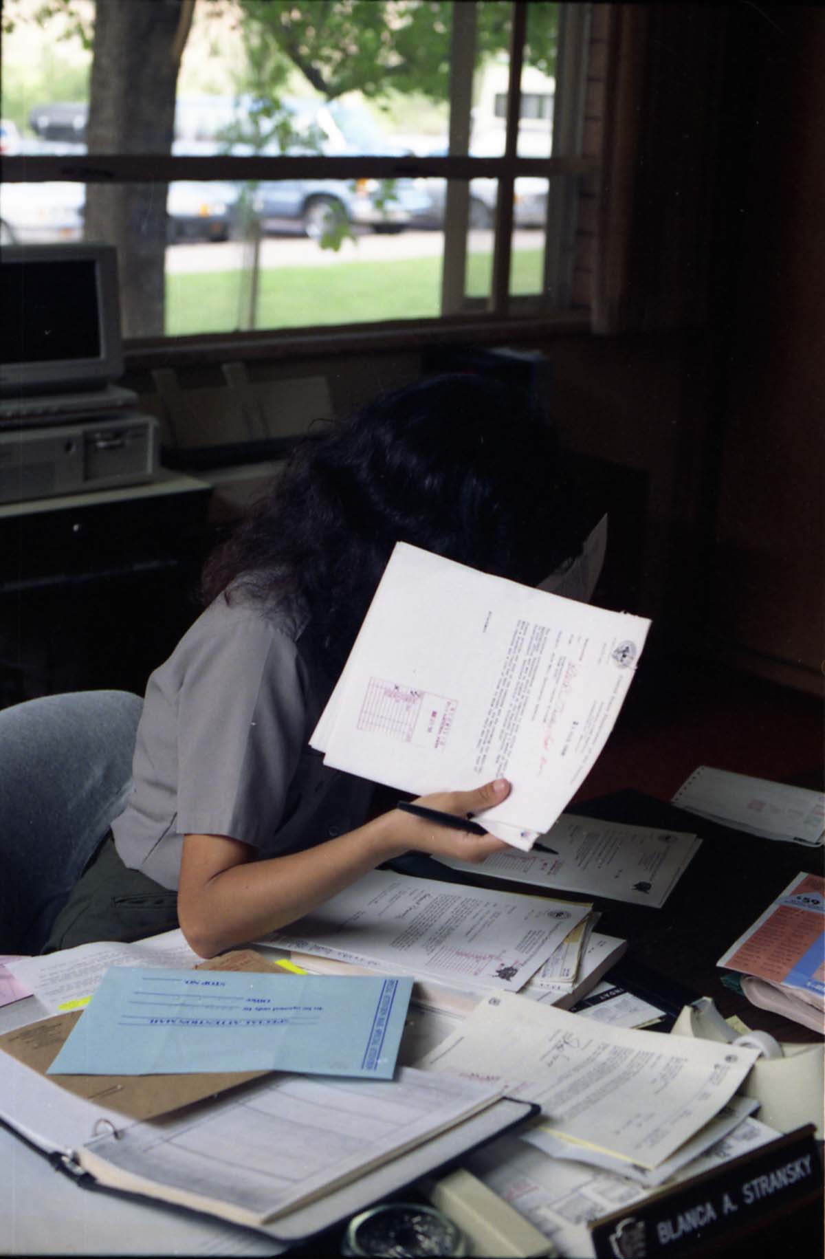 Color Photos of administration personnel. Blanca A. Stransky hiding behind memorandum.