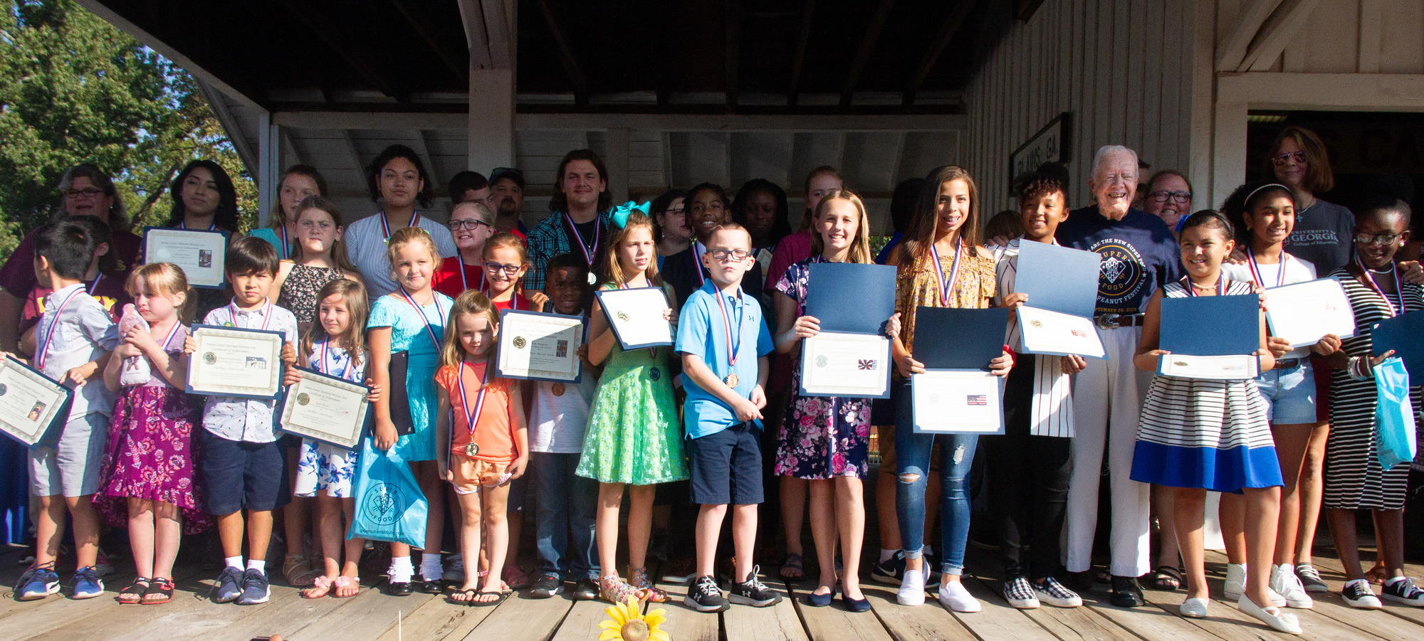 Winners of the 2018 postcard contest onstage at the Plains Depot with President Carter.