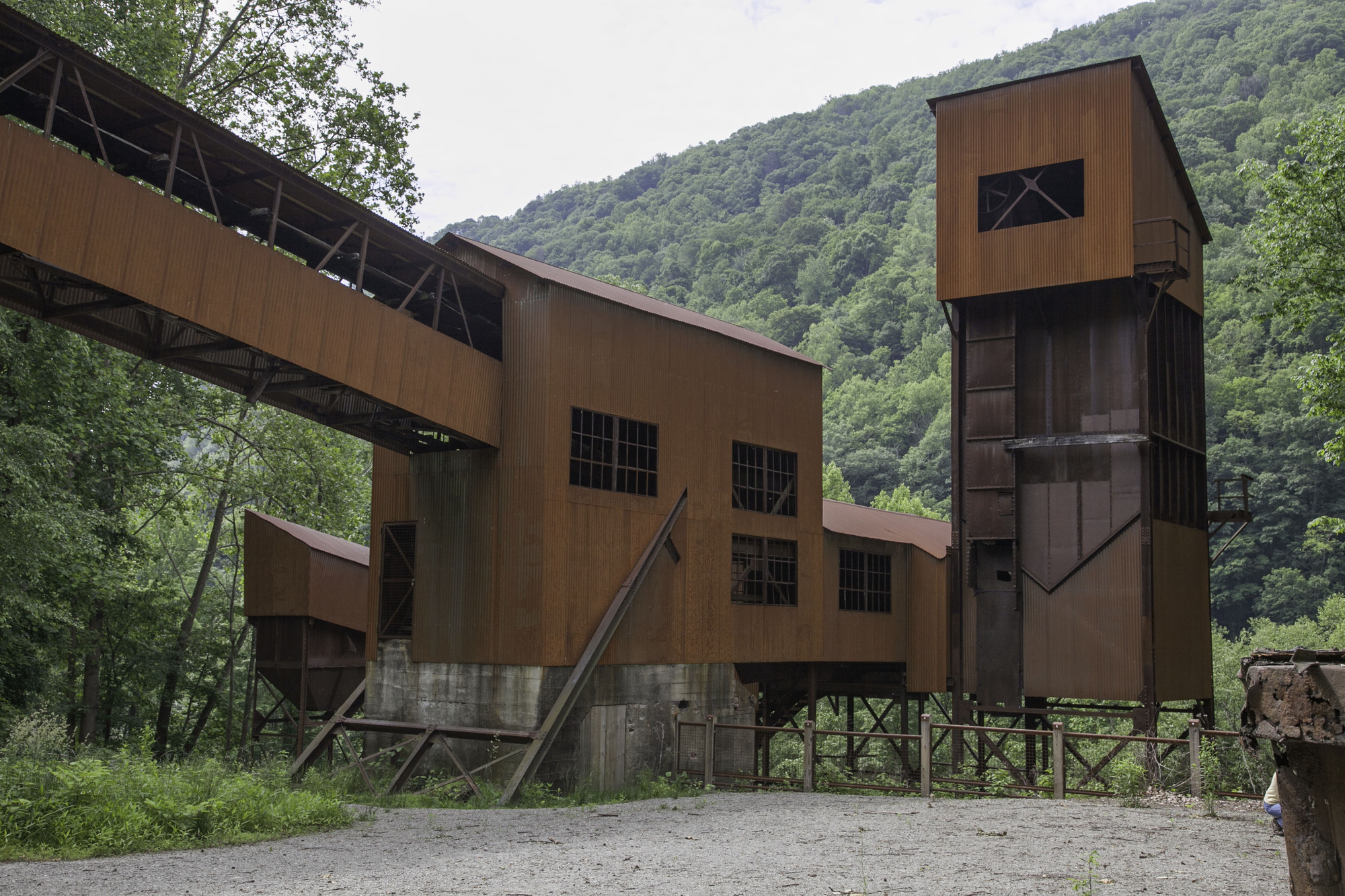 rusted metal building with coal conveyor feeding into it