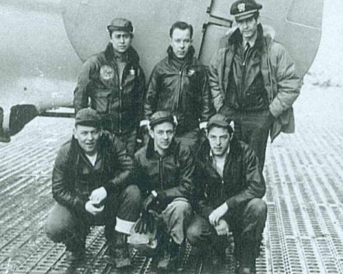 Six airmen pose in front of their bomber