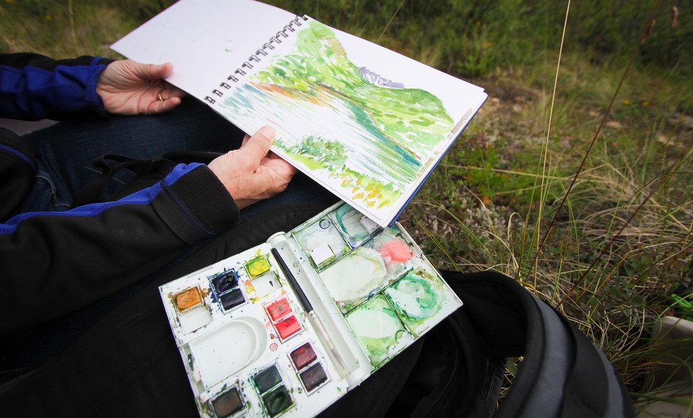 Artist Trine Bumiller paints in the field.