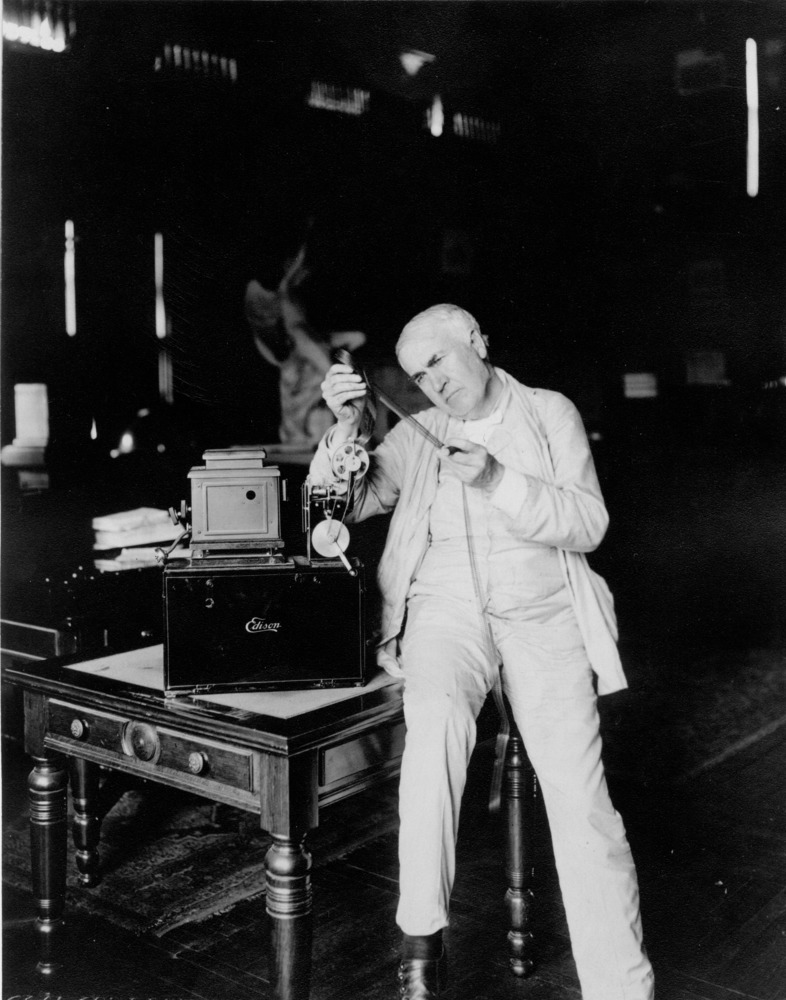 Thomas Edison looking at his motion picture projector made for the home.