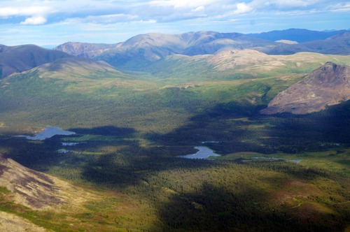 a wide valley filled with trees and two lakes, surrounded by mountains on either side