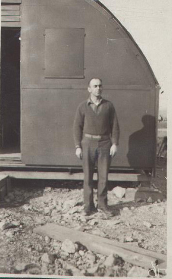 Man in front of a quonset hut