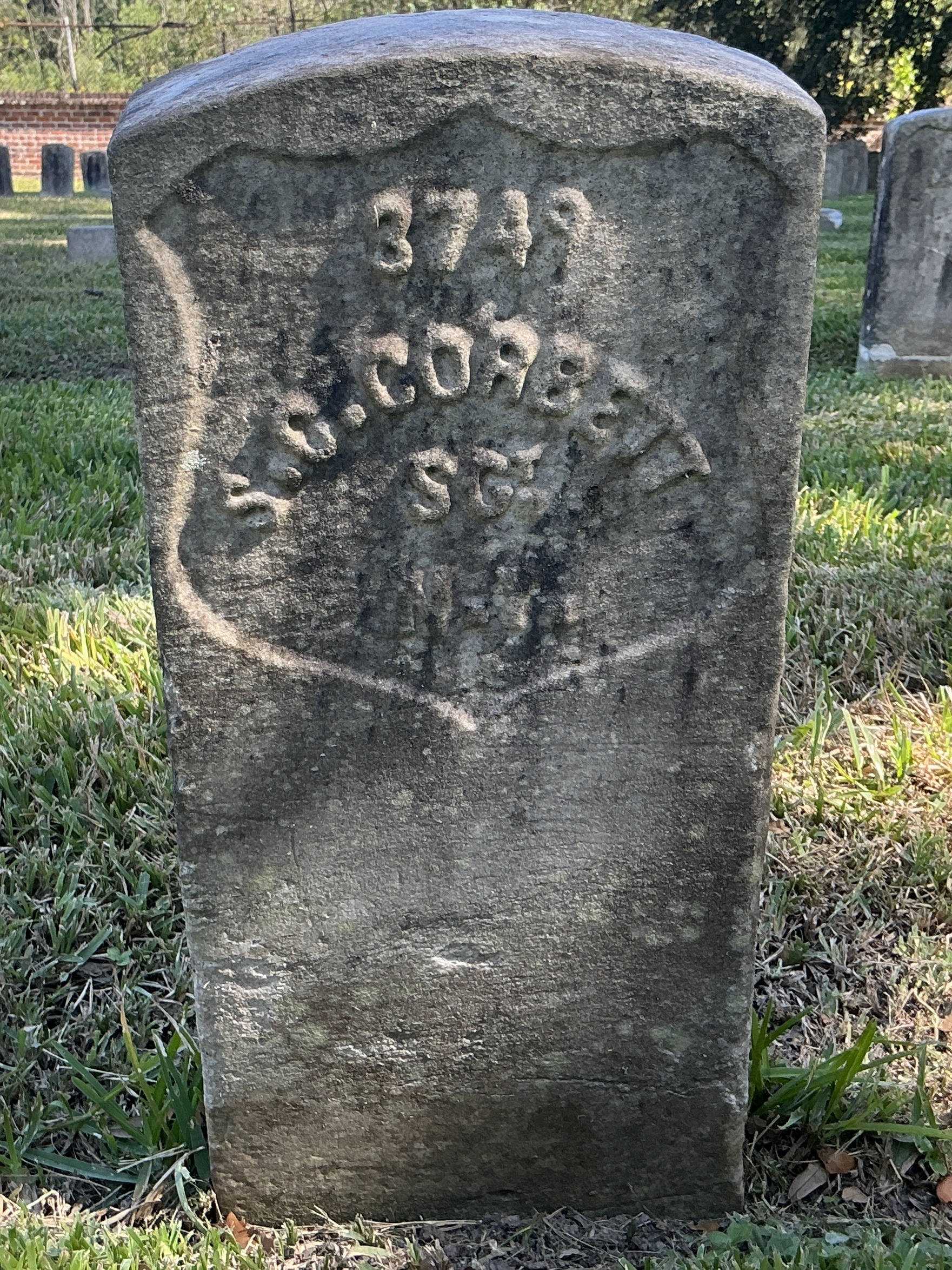 Front of historic upright marble headstone with recessed shield face.
