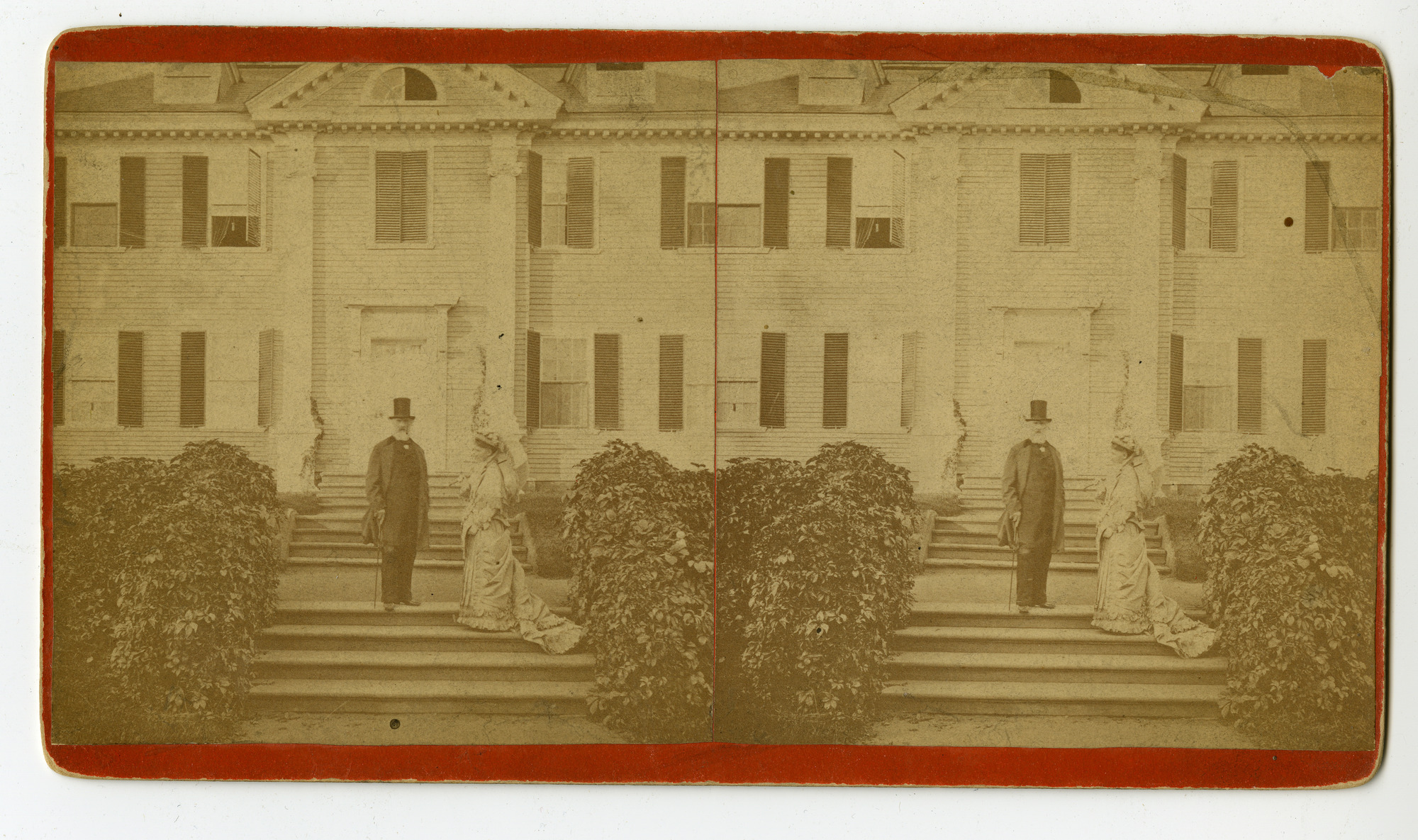 Man and a woman stand in front of Georgian mansion.