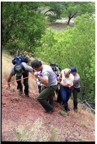 Color photo of SAR team transporting injured man.