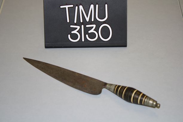 a knife with a decorative handle featuring rings in black, brass, and yellow. 