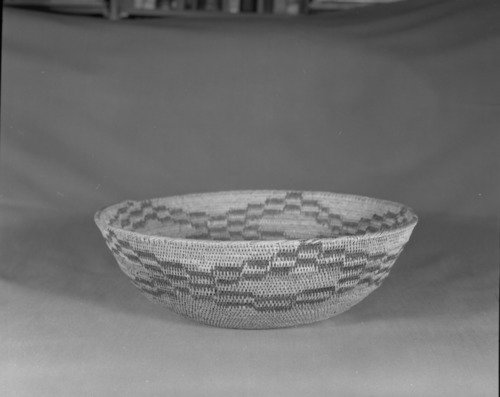 Private Collection. Object: Miwok basket. Dimensions: 12 1/4 x 4". Materials: Red bud, split bull pine and top 1/3 of basket possibly finished in split ceanothus. Technology: Single rod, fag ends trimmed on work face, moving ends trimmed on interior. Leftward coil direction. Rim overstitched. Collection History: Technology like Matilda's, a Sonora Miwok, but attribution not certain. Photographed by Michael Dixon. Catalogued by Craig Bates and Barbara Beroza. Yosemite Collections, National Park Service.
