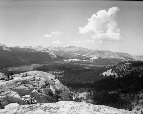 The wilderness of the Yosemite High Sierra to the west of Lembert Dome in Tuolumne Meadows with a portion of the meadows in the foreground and Mt. Hoffman and Tuolumne Peak in center background.