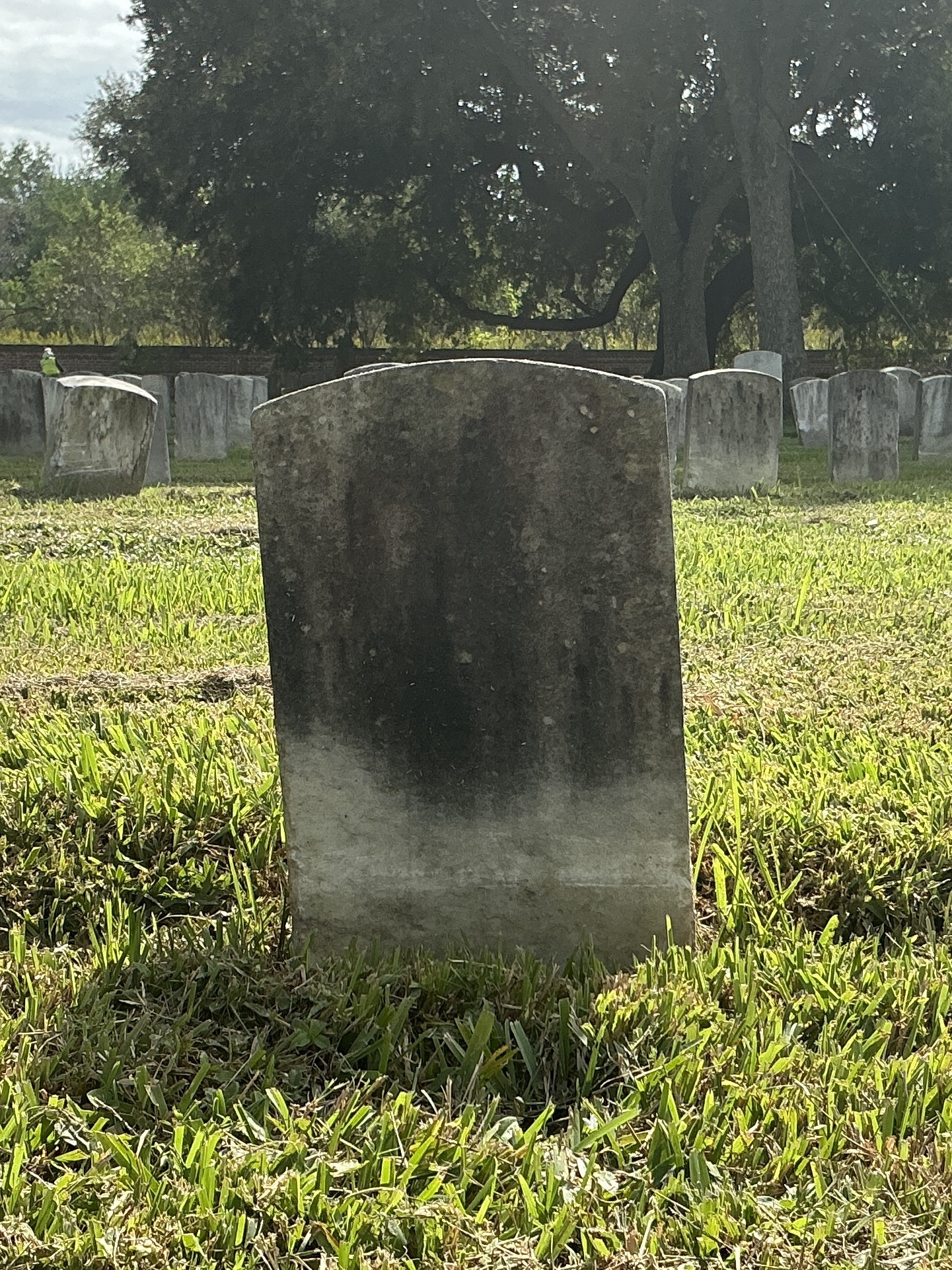Back of historic upright marble headstone with recessed shield face.