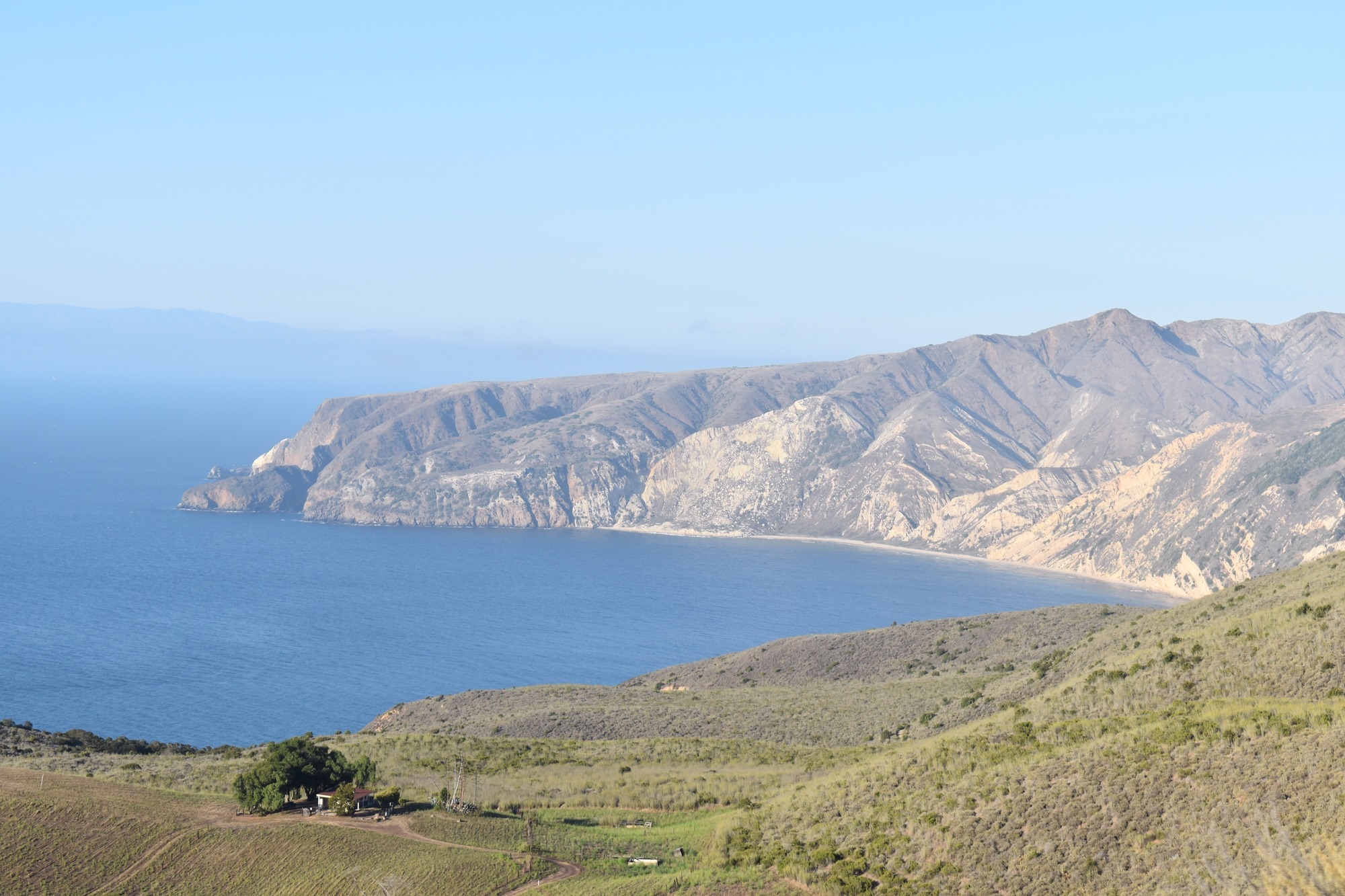View of small cabin vintage with ocean and island mountains in the background and a blue sky