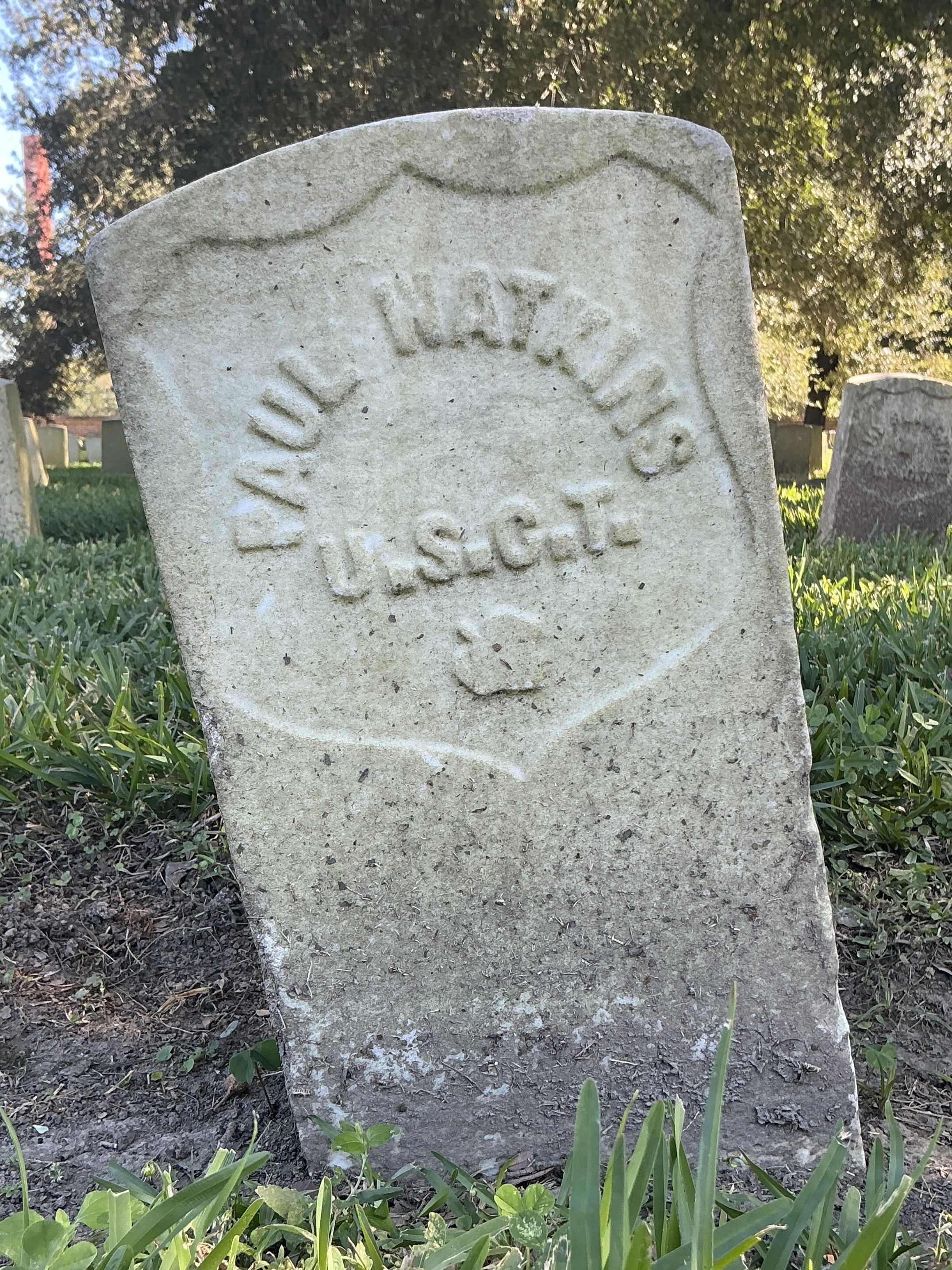 Back of historic upright marble headstone with recessed shield face.