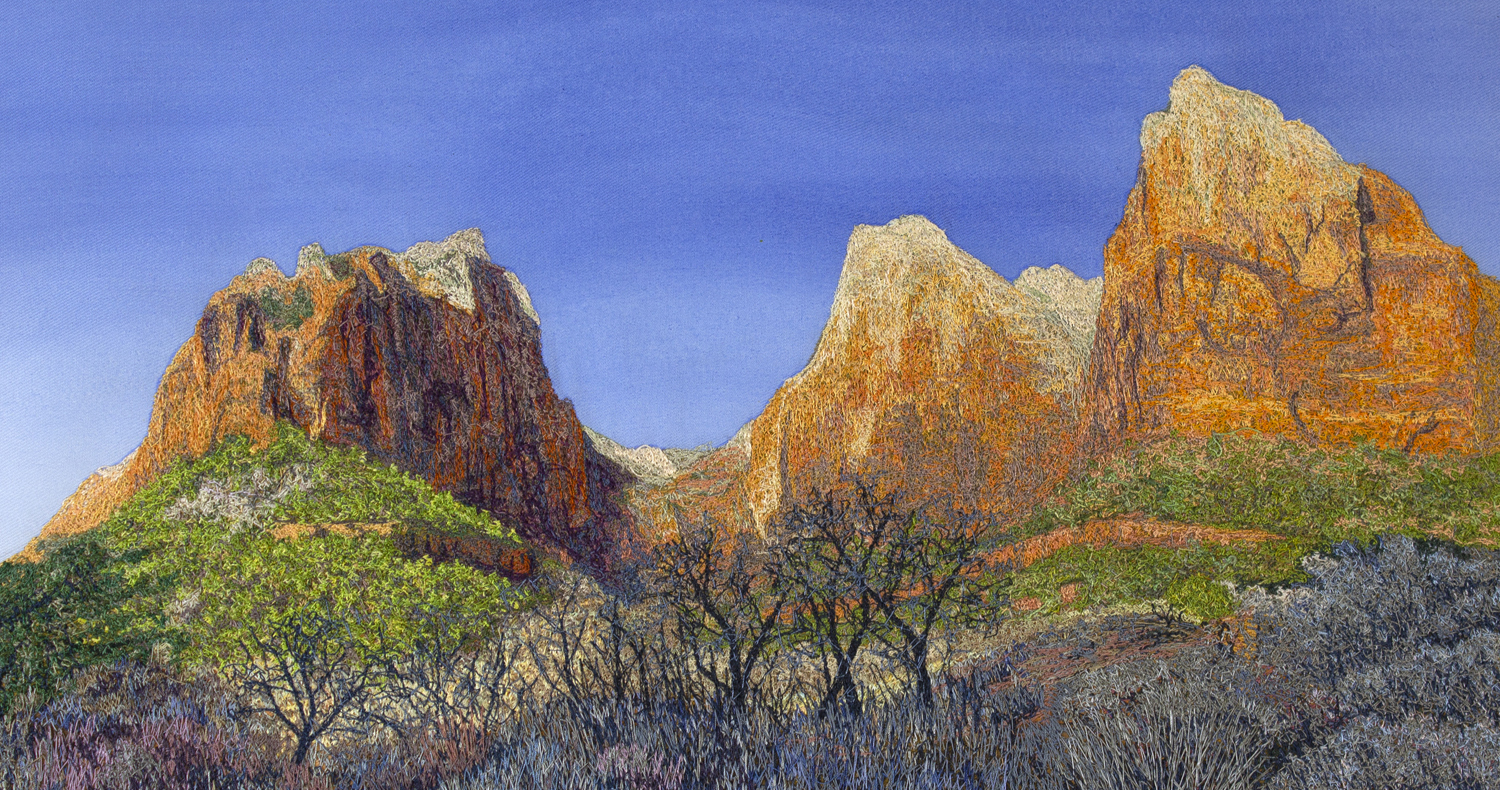 An image created using colored thread and fabric. This view shows the Court of the Patriarchs, a series of sandstone peaks that stand tall above the landscape. In the foreground, various dry shrubs and trees are shown. In the middleground, lush green hillsides form a slope up to the base of large cliffs. In the background, massive sandstone peaks stand in front of a deep blue sky.