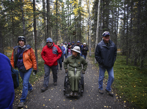 a ranger and park visitors on a trail in a forest