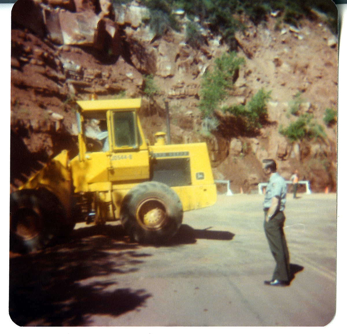 Worker watches as tractor performs gravel/draining operations along the Zion-Mt. Carmel Highway switchbacks.