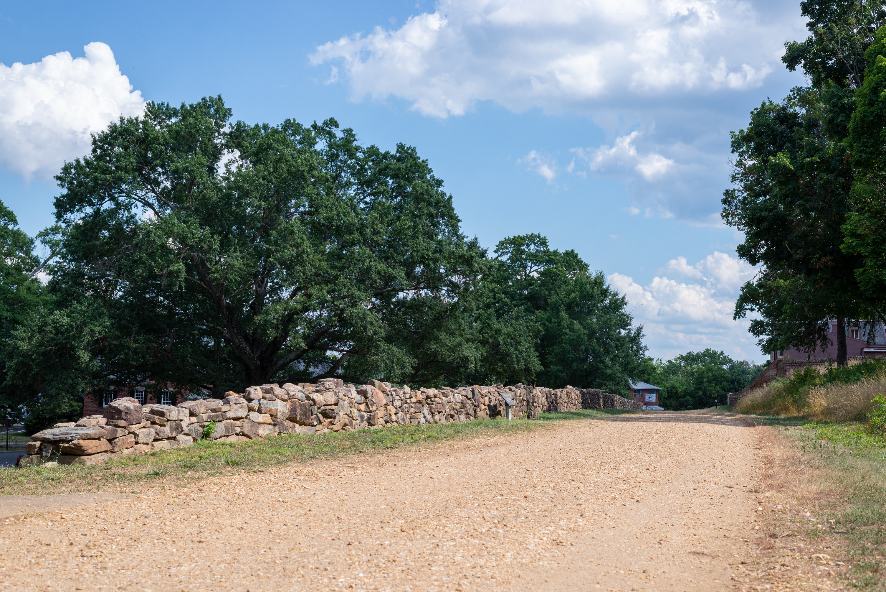 A gravel road lined by a stone wall