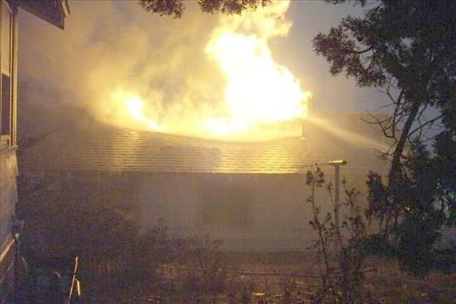 Night photos of a house burning during the Long Mesa fire in Mesa Verde National Park, July-August 2002