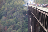 Eleven base jumpers leaping from bridge while crowds watch