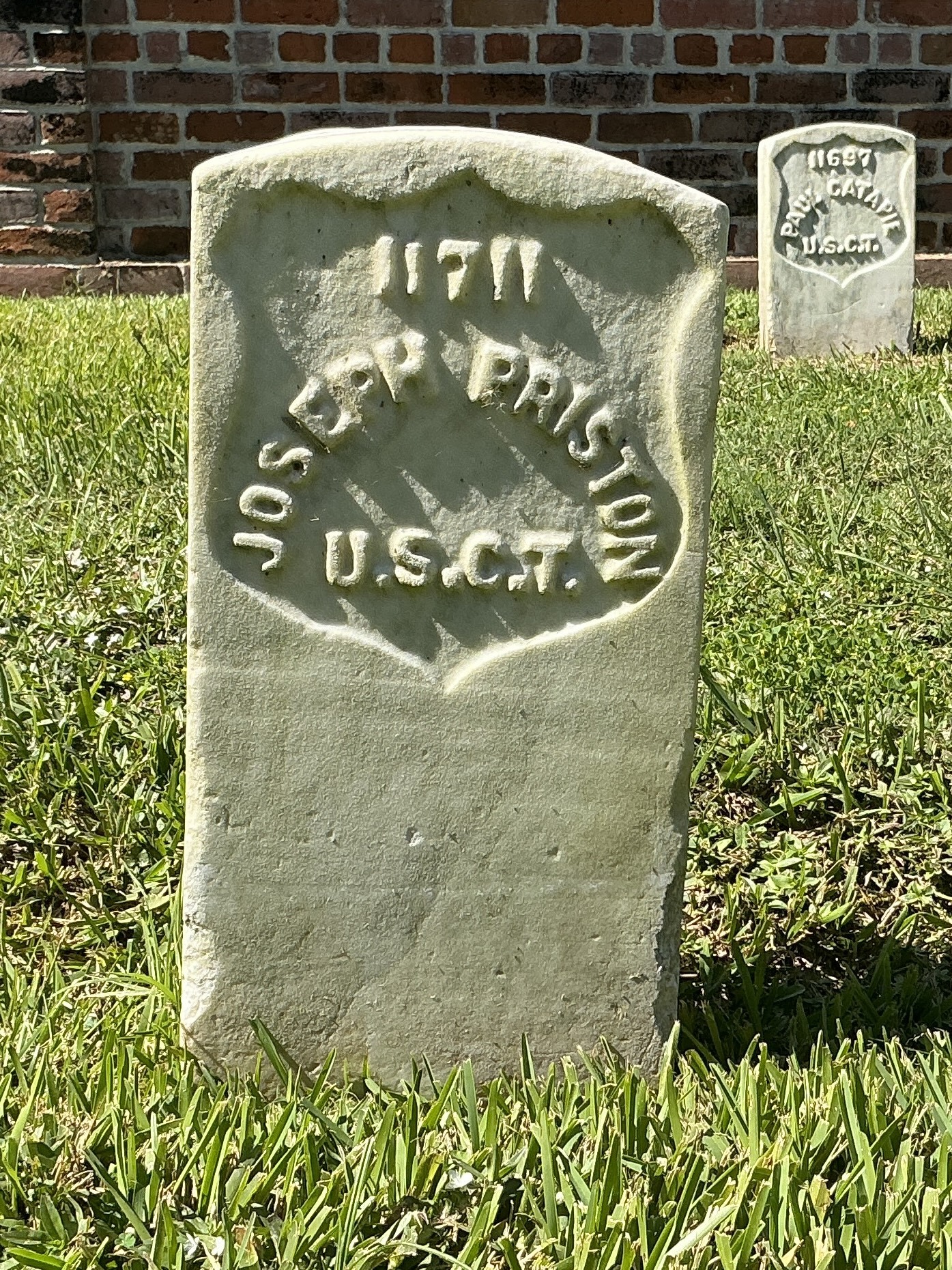 Front of historic upright marble headstone with recessed shield face.