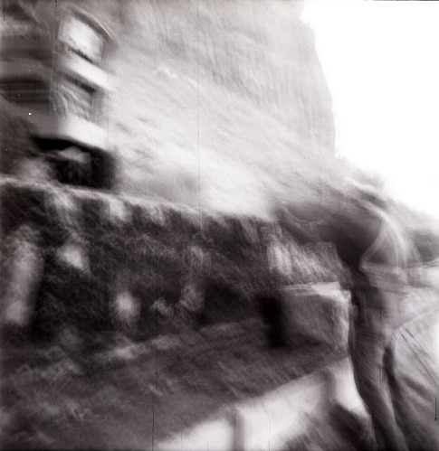 Man working on rebuilding rock retainer wall alongside road at the tunnel.