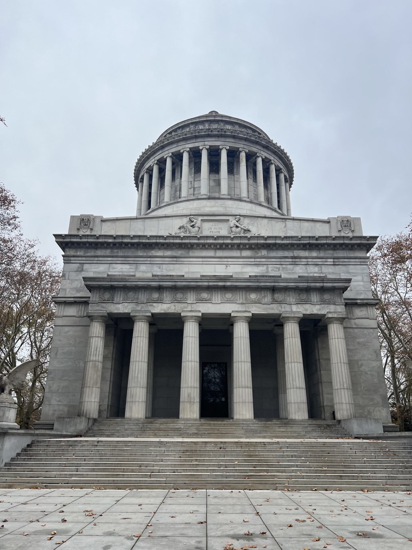 A large, granite mausoleum on a cloudy day.