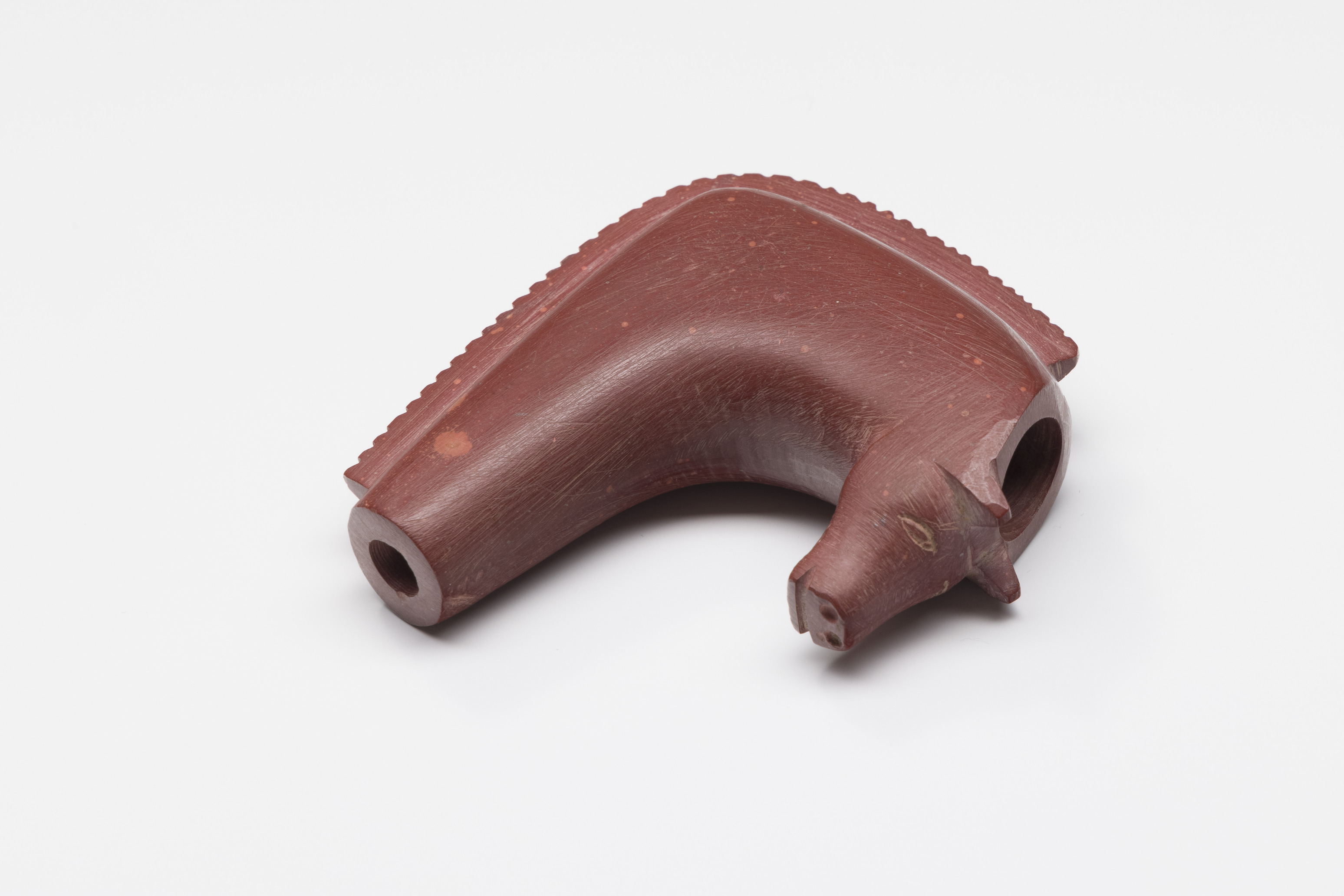 Red stone pipe head in form of a horse's head.