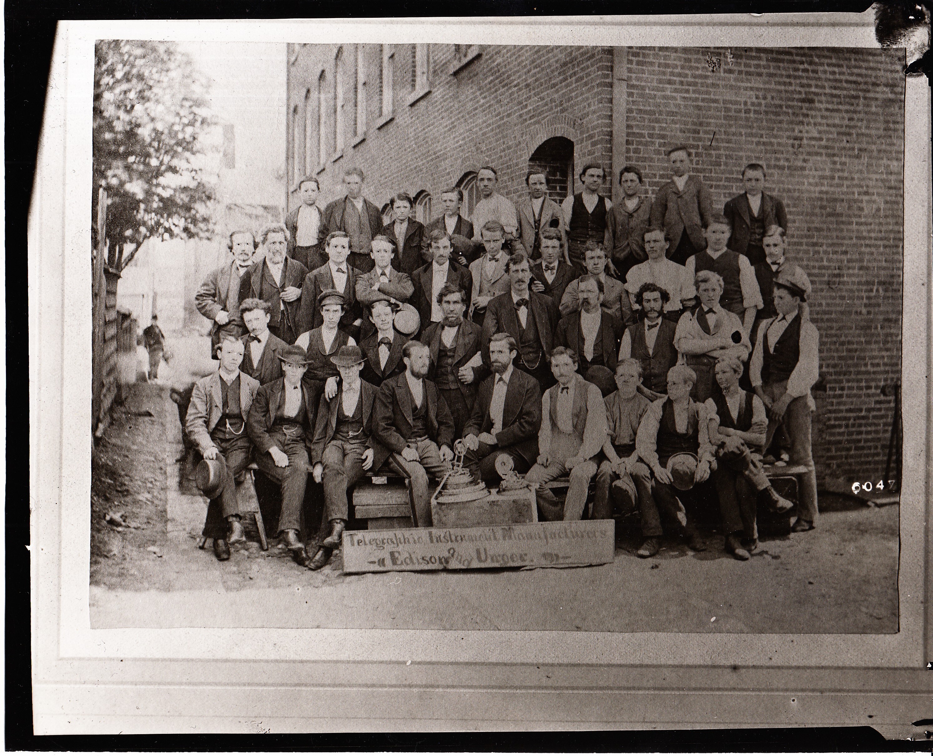Edison and Unger employees, telegraphic instrument makers, photographed in Kirk's alley behind building at 10-12 Ward St.