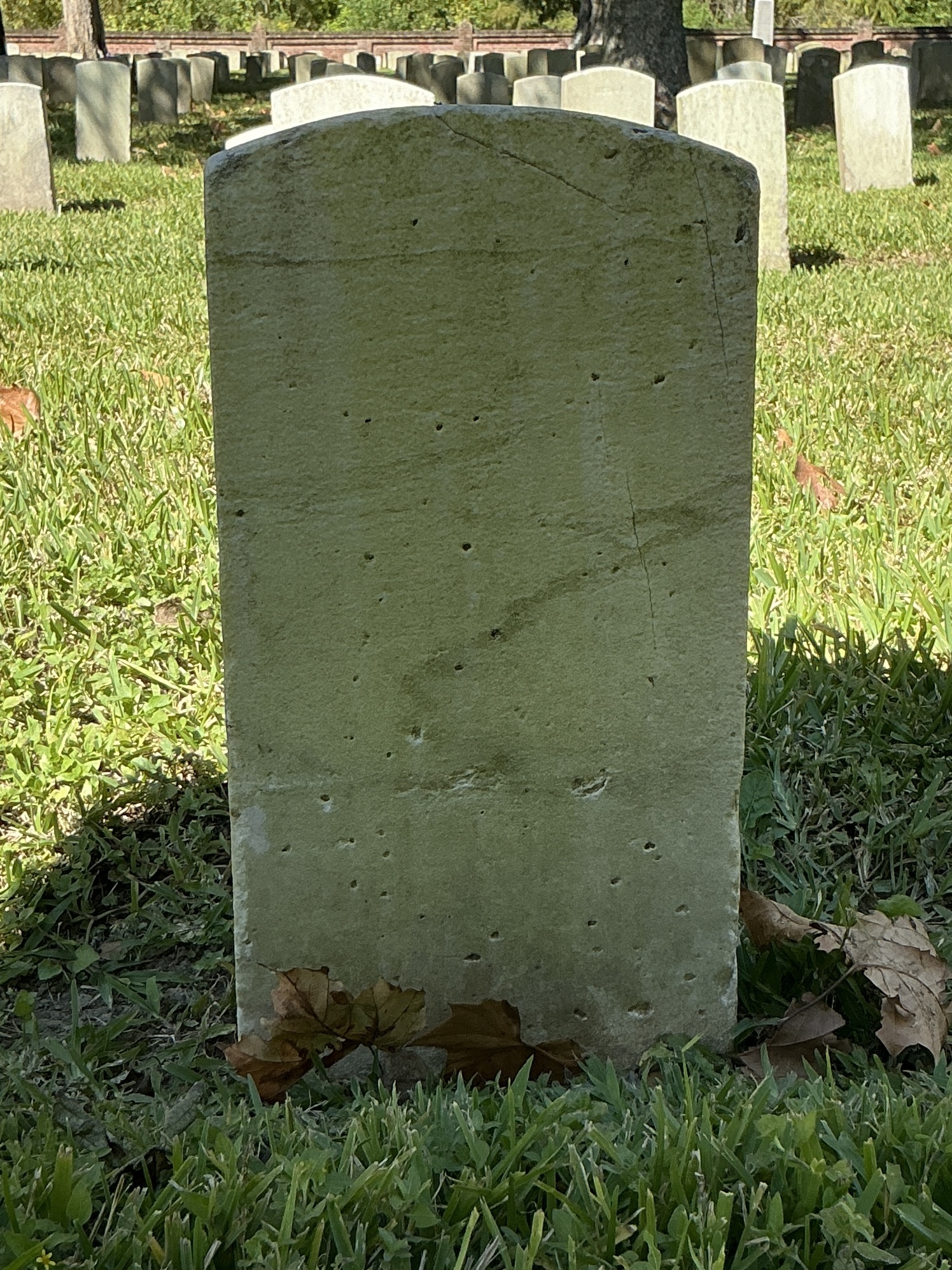 Back of historic upright marble headstone with recessed shield face.