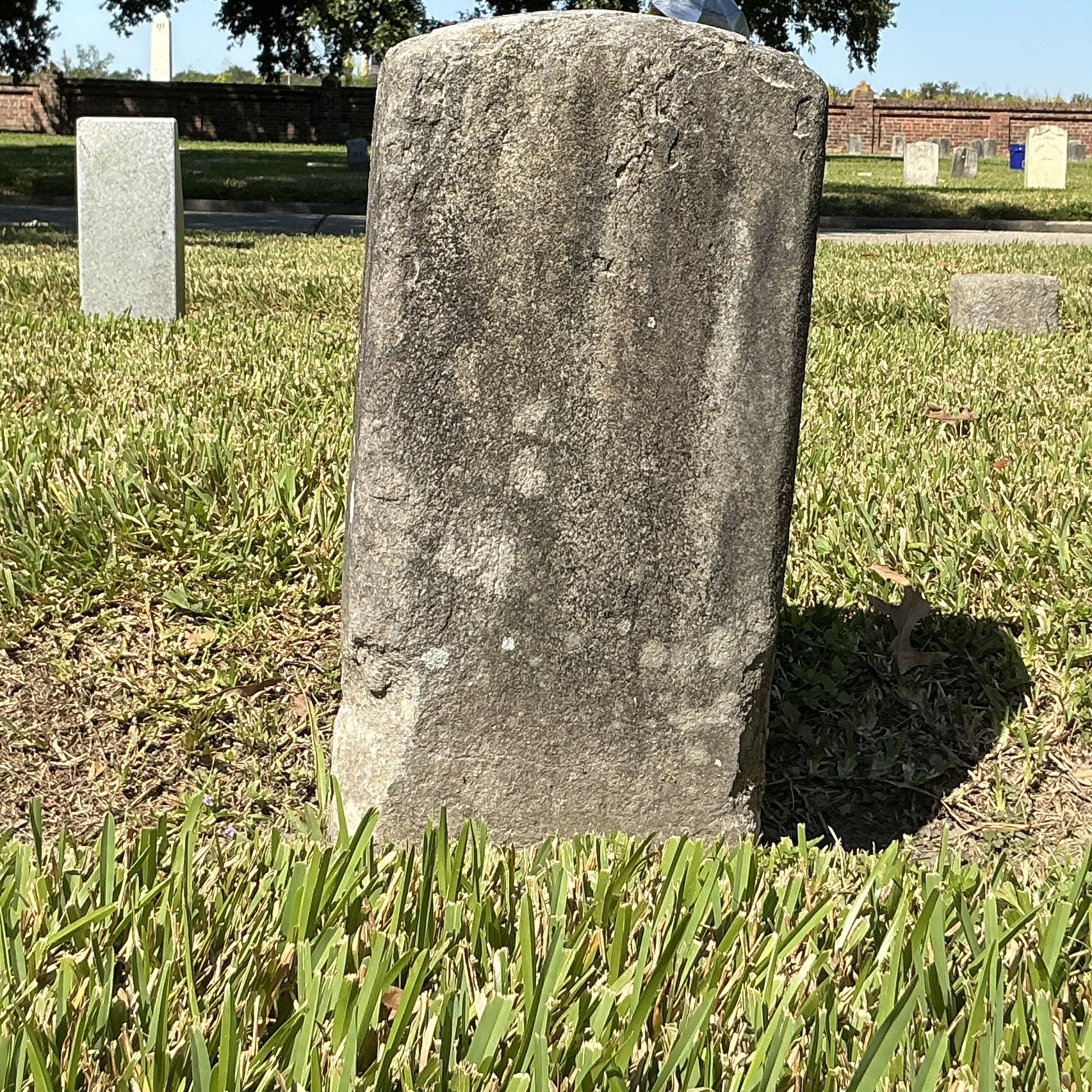 Back of historic upright marble headstone with recessed shield face.