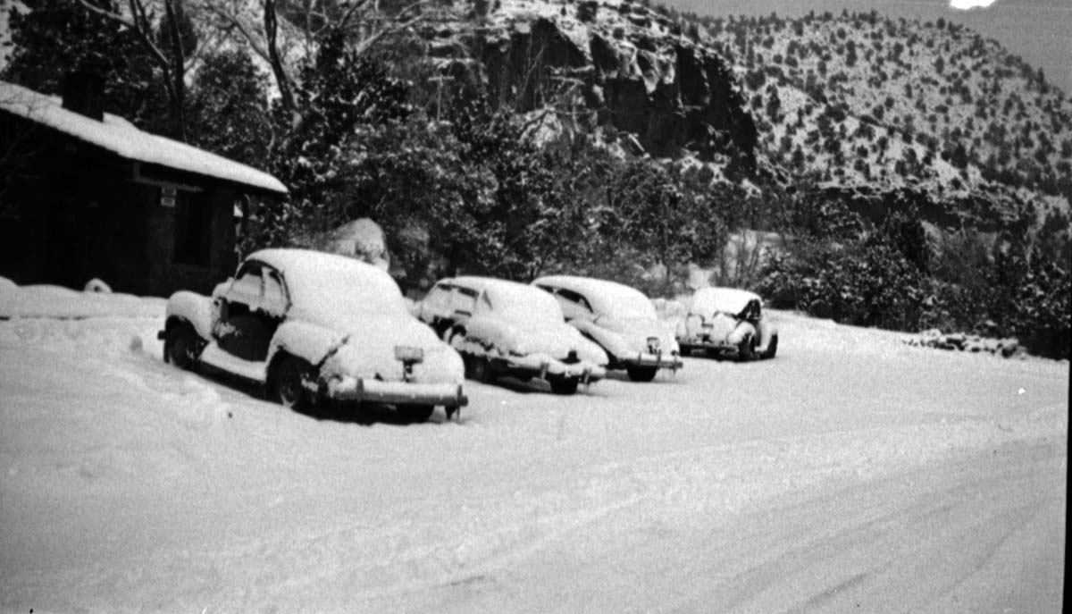 Snowstorm and covering of cars in front of museum.