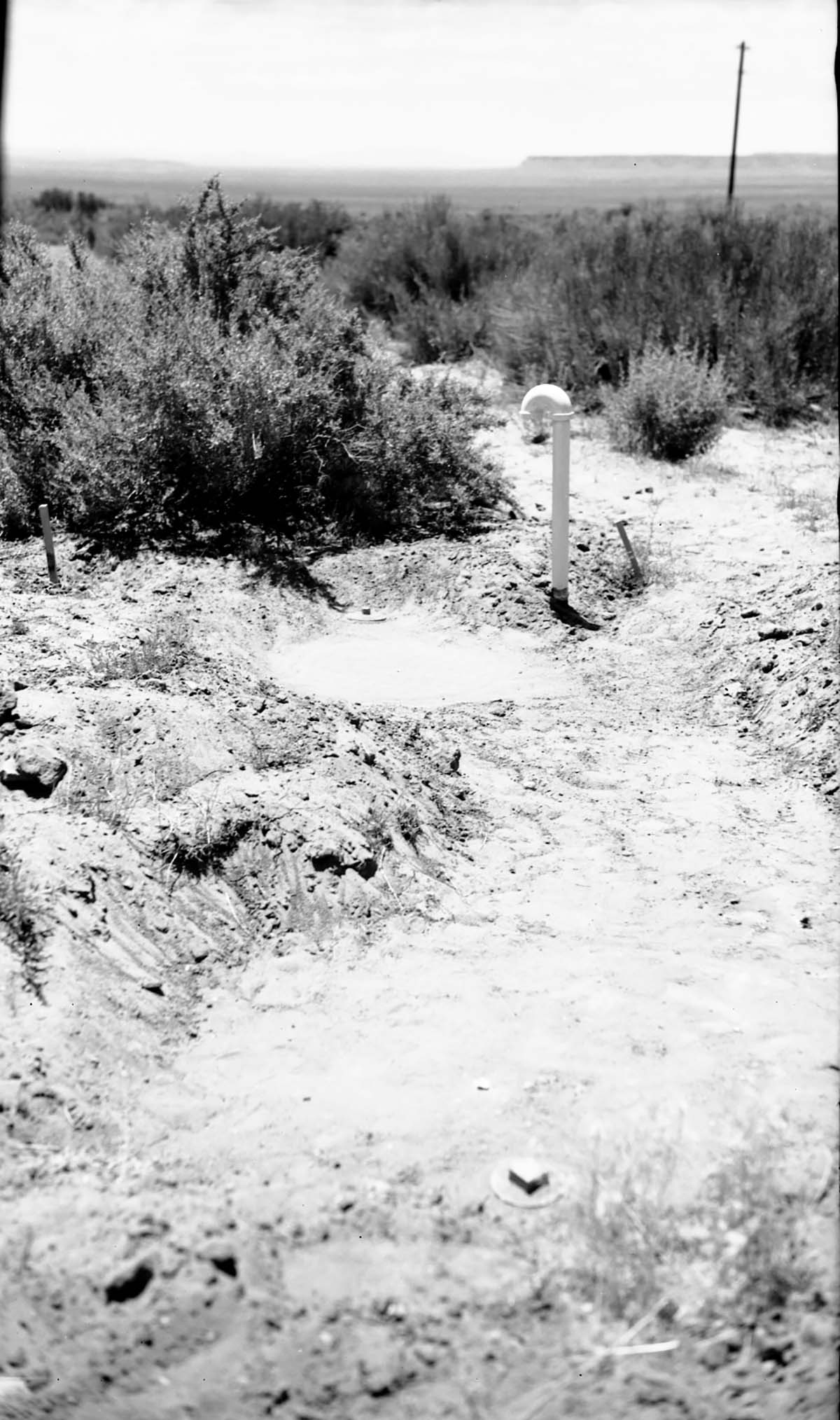 Partially uncovered septic tank at Pipe Spring before new leach field installation. Note manhole and plugs.